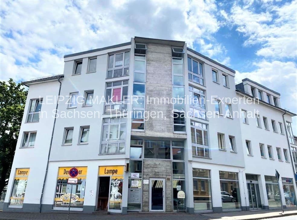 Vier-Geschoss-Eckhausblock mit weißer Fassade, Natursteinelementen an der Ecke, Lindenthaler Hauptstraße in Leipzig