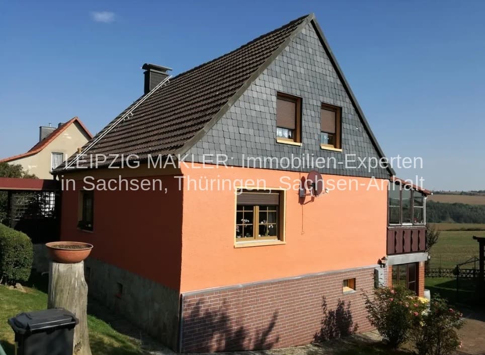 Einfamilienhaus mit Satteldach, Ziegeln gedeckt, Fassade orange und grau gestrichen, Backsteinzockel, Kellergeschoss