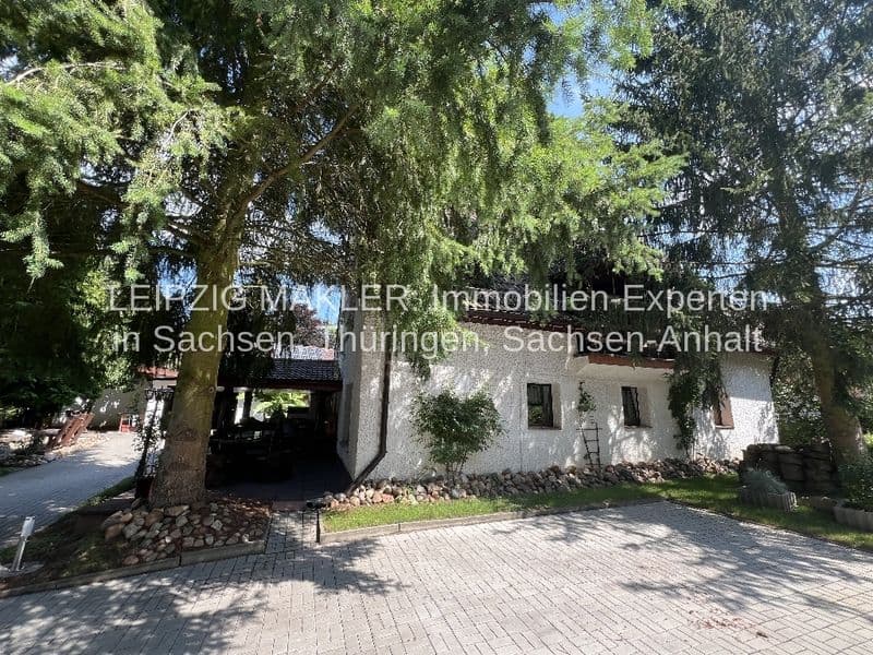 Einstöckiges Wohnhaus mit weißer Putzfassade, Carport mit dunklem Dach links, alter Baumbestand, Splau in Bad Schmiedeberg