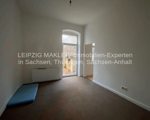 Leerer Raum mit Glastür zum Balkon, Heizkörper an der Wand, dunkler Bodenbelag, Frankenberger Straße in Chemnitz-Ebersdorf