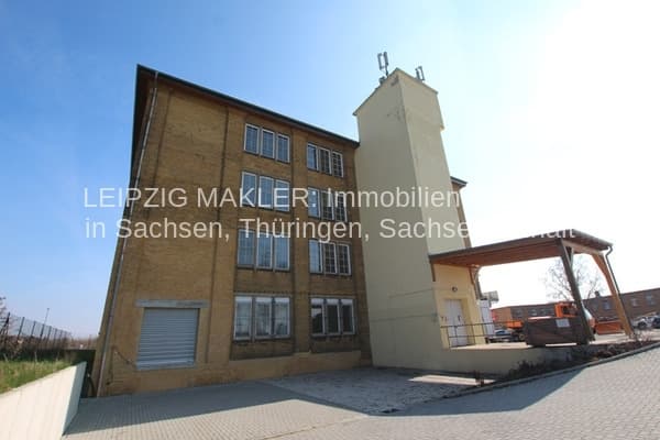 Dreigeschossiges Gewerbegebäude mit Klinkerfassade, angebauter Turm und Flachdach, Hoffläche mit Pflaster, Leipzig-Wahren