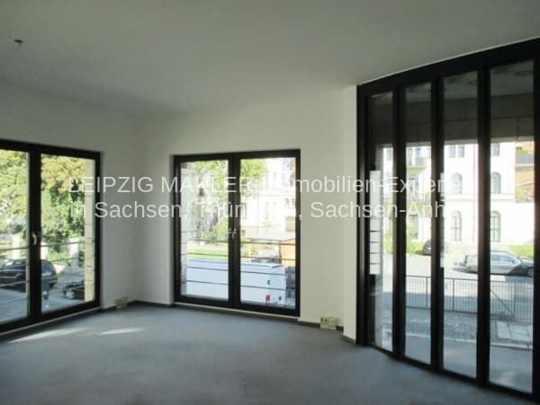 Leerer Raum mit hellen Wänden, Betonboden und großflächigen Fensterfront mit schwarzem Rahmen, Goldschmidtstraße in Leipzig