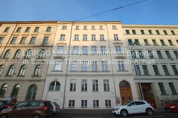 Fünfgeschossige Gründerzeitfassade mit Werksteinfugen und regelmäßiger Fensterreihe, Erdgeschoss mit Rundbogenfenster