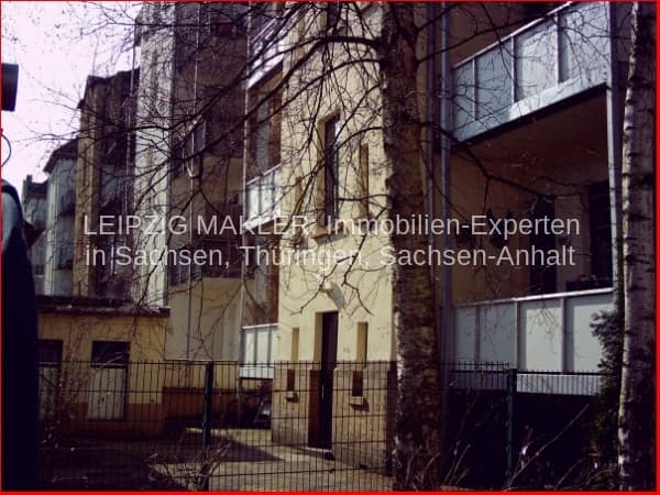 Mehrfamilienhaus mit vier Geschossen, gelber Putzfassade, Fensterreihen und Balkon, Schnorrstraße in Leipzig