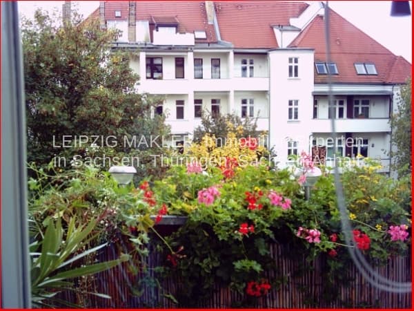 Mehrfamilienhaus mit weißer Fassade, Satteldach mit roten Ziegeln und Balkon, Sassstraße in Leipzig