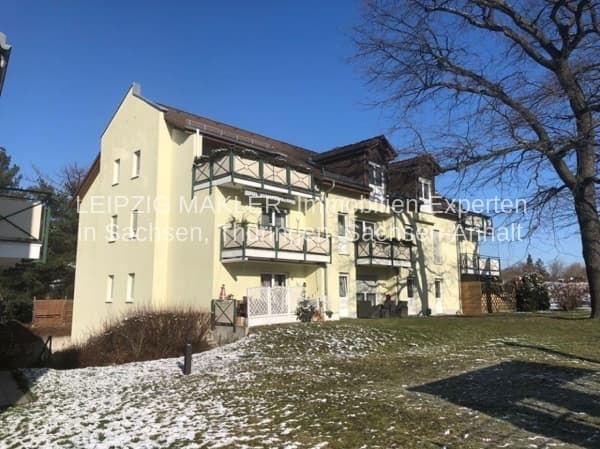 Zweistöckiges Wohnhaus mit Putzfassade in Creme, Fachwerk an Balkonen, Satteldach, Cleudner Straße in Leipzig-Thekla