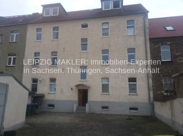 Viergeschossiges Wohnhaus mit Mansardendach, heller Fassade und regelmäßiger Fensteranordnung, Feldstraße in Bitterfeld