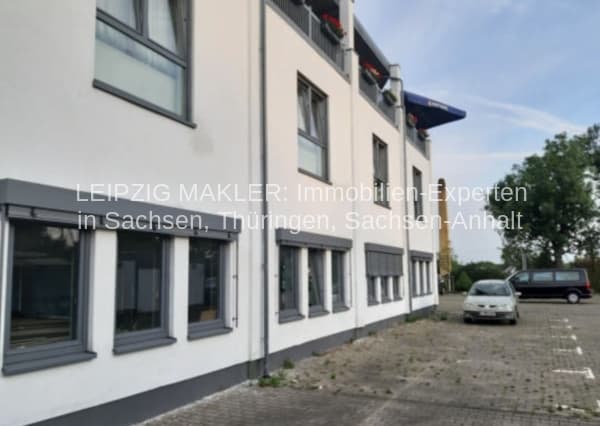 Dreigeschossiges Wohnhaus mit weißer Fassade, dunkelgrauen Fensterrahmen und Satteldach, Hallesche Straße in Leipzig