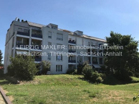 Viergeschossiger Wohnblock mit Mansardendach und Balkonen, Grünfläche im Vorbereich, Blankenfelder Straße in Berlin