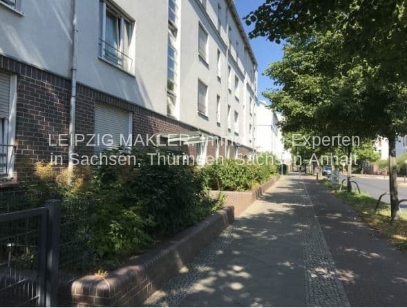 Mehrgeschossiges Wohnhaus mit Klinker- und Putzfassade, Bäume und Weg im Vordergrund, Blankenfelder Straße in Berlin