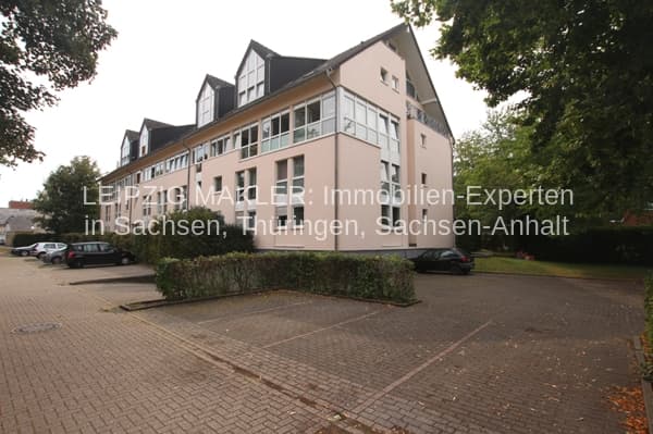 Mehrfamilienhaus mit Mansarddächern und Gauben, Putzfassade, Fensterreihen, von Bäumen umgeben, Gartenstraße in Eschweiler