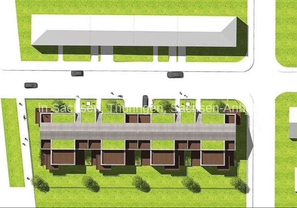 Lageplan einer Wohnanlage mit zwei parallelen Gebäuden, mehreren Parkplätzen und Grünflächen mit Bäumen