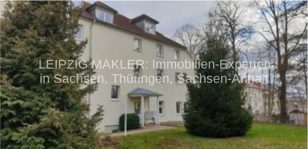 Dreigeschossiges Wohnhaus mit Mansardendach, heller Fassade, Eingangsportal und Heckenumrandung, Talstraße in Fraureuth