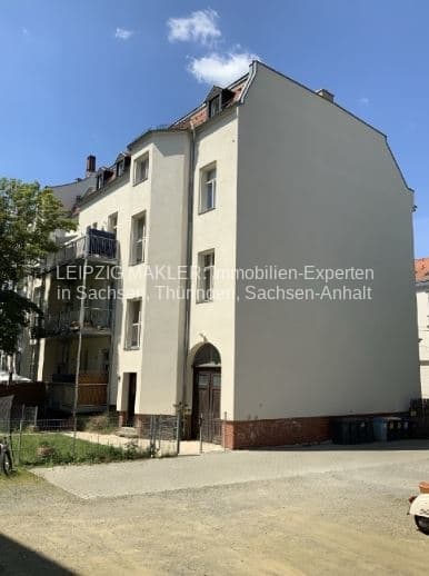 Viergeschossiges Wohnhaus mit Mansardendach, heller Fassade und rotem Sockelsockel, Platnerstraße in Leipzig