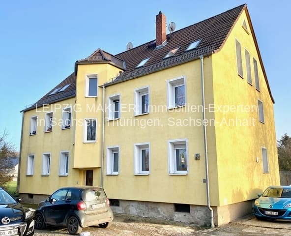 Zweigeschossiges Wohnhaus mit gelber Fassade, Satteldach, Ziegeln, Kamin und mehreren Fenstern, Dewitzer Straße in Taucha
