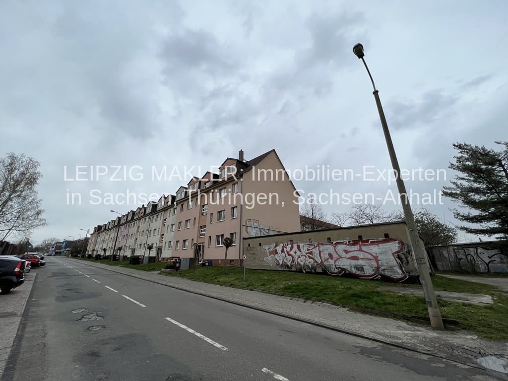 Mehrgeschossige Wohnzeile mit Mansarddach, Putzfassade, Straßenseite mit Parkplätzen, Mockau in Leipzig-Mockau-Süd