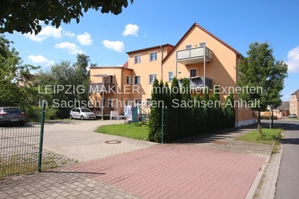 Zweigeschossiges Wohnhaus mit Satteldach und gelber Fassade, Balkon, gepflasterte Zufahrt, Ochelmitzer Straße in Jesewitz