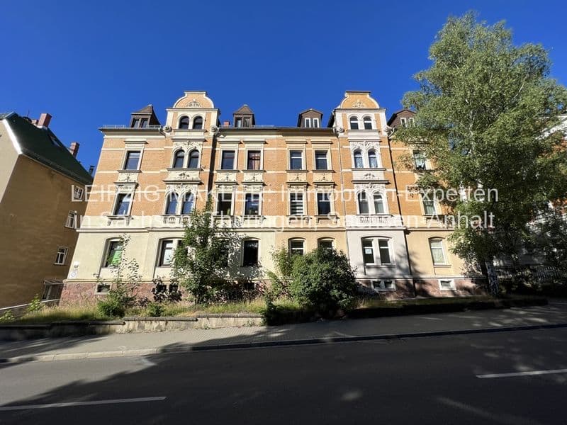Gründerzeitlicher fünfgeschossiger Wohnbau mit Mansarddächern, Rustika-Fassade und Fenstergruppen