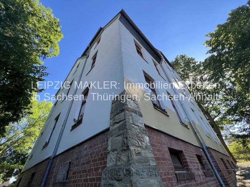 Vier-Geschoss-Eckhaus mit Satteldach, Ziegelsockel und verputzte Fassade, umgeben von Bäumen, Waldstraße in Crimmitschau