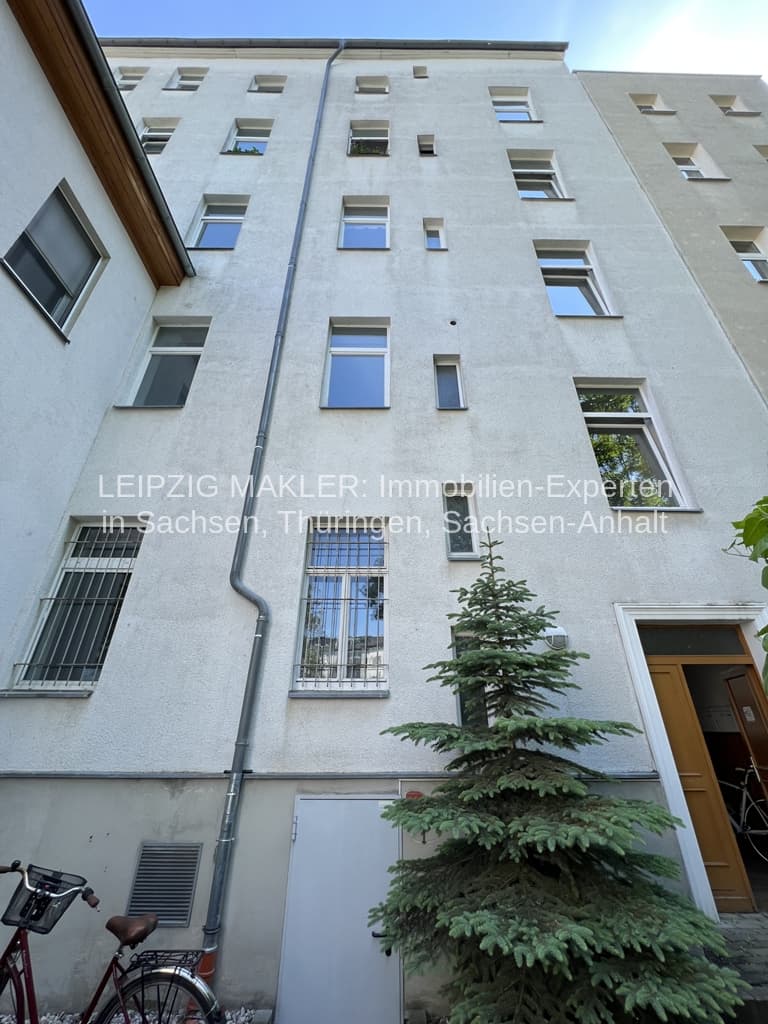Fünfgeschossiger Wohnblock mit heller Putzfassade, regelmäßig angeordneten Fensterfluchten