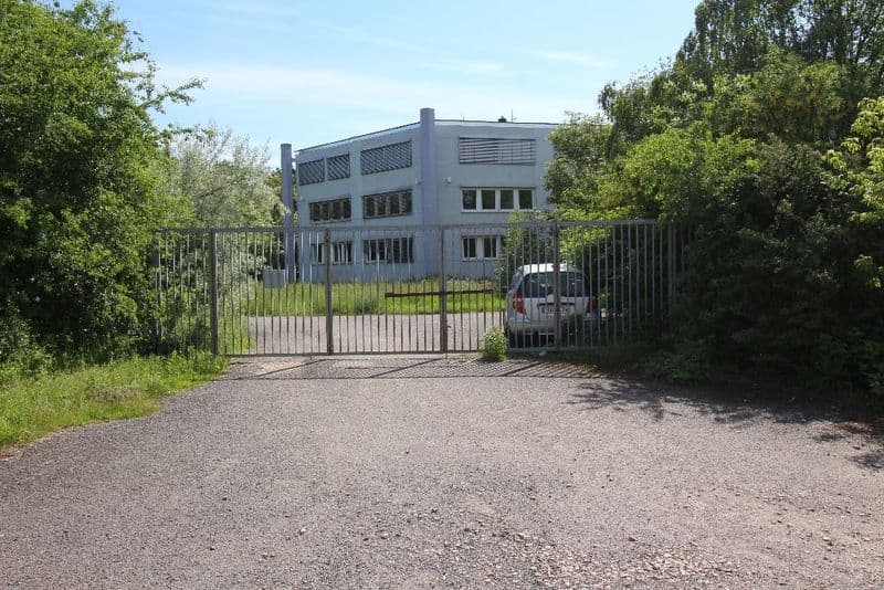 Dreigeschossiges Gewerbegebäude mit grauer Fassade, Flachdach und Lüftungsanlagen, umzäunt, Rosenweg in Borsdorf