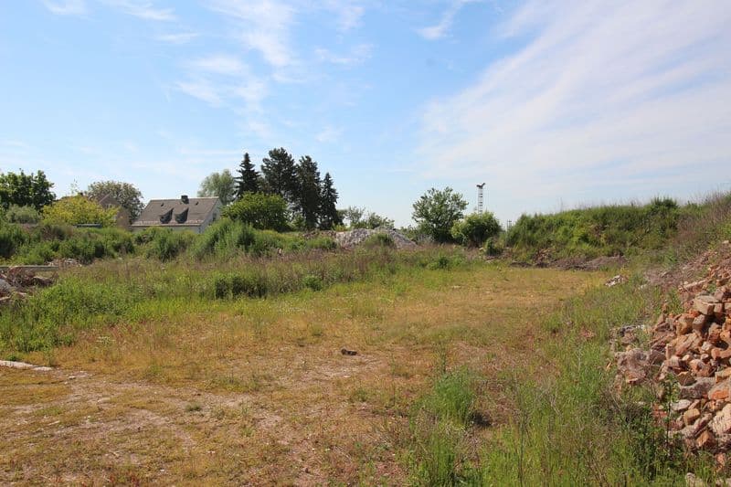 Freies Grundstück mit Wiese und Böschung, dahinter Wohnhaus mit Satteldach, Rosenweg in Borsdorf