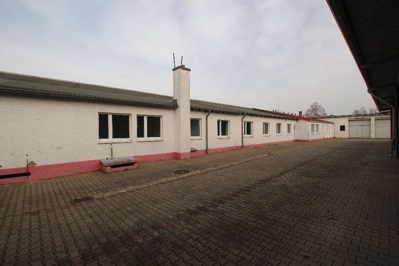 Langgestrecktes Gewerbegebäude mit weißer Fassade, roten Sockelstreifen, Bitterfelder Straße in Leipzig-Eutritzsch