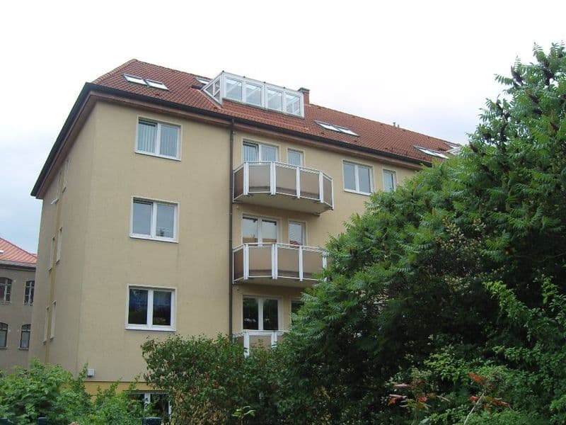Viergeschossiges Wohngebäude mit gelblicher Putzfassade, Walmdach mit roten Ziegeln, Dieskaustraße in Leipzig