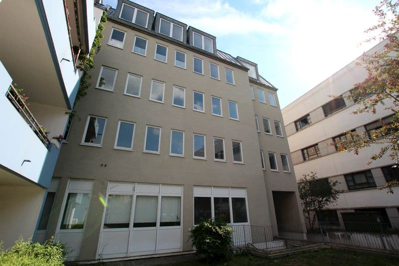 Fünfgeschossiges Wohngebäude mit Satteldach und Gauben, beige Putzfassade, Emilienstraße in Leipzig