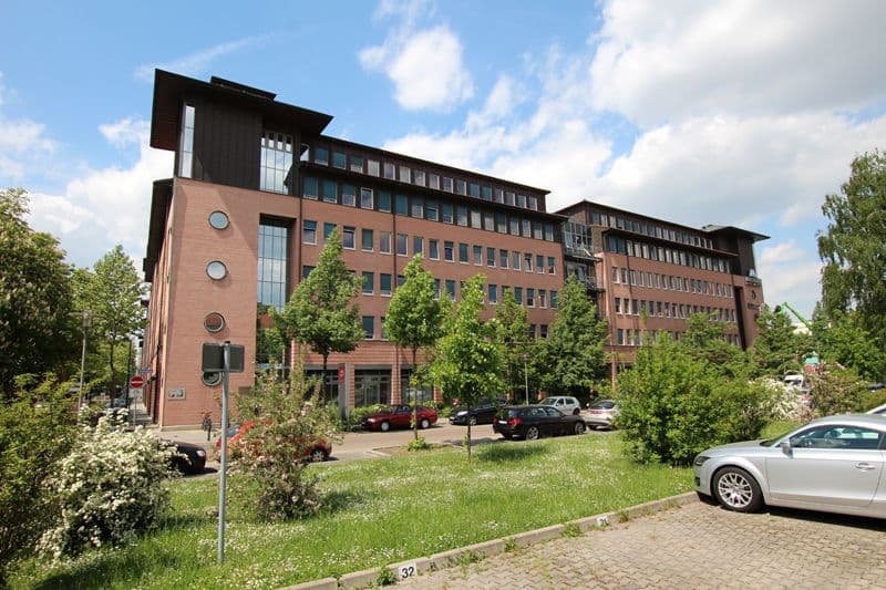 Fünfgeschossiges Bürogebäude mit Backsteinfassade und schwarzen Dachaufbauten, Großer Brockhaus in Leipzig