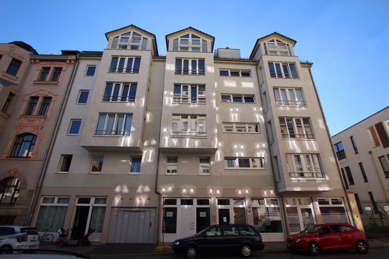Fünfgeschossiges Wohn- und Geschäftshaus mit Satteldächern, beige Fassade, Hans-Poeche-Straße in Leipzig