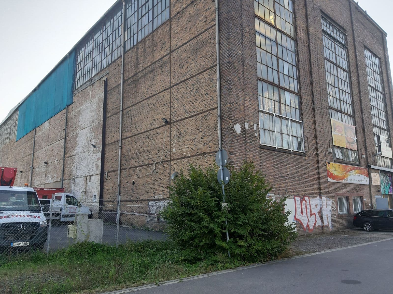 Mehrstöckiges Backsteingebäude mit großflächigen Fensterbandern und teilweise blauem, Maximilianallee in Leipzig-Eutritzsch