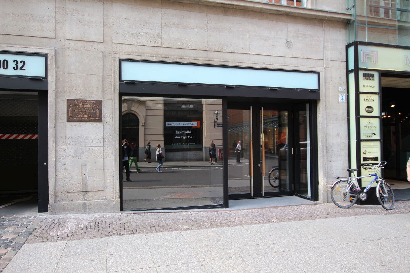 Ladengeschäft mit großflächiger Glasfront, heller Natursteinfassade und schwarzem Rahmen, Neumarkt in Leipzig-Zentrum