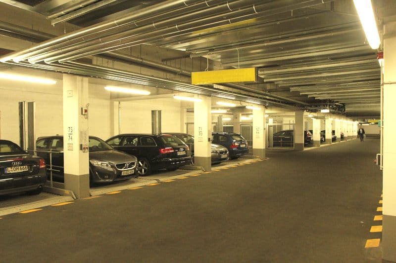 Tiefgarage mit Betondecke, Stahlstützen, asphaltiertem Boden, Parkplätzen und LED-Beleuchtung