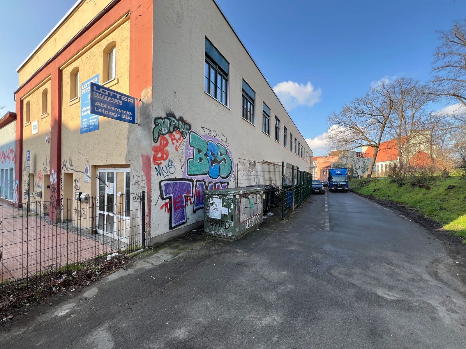Mehrgeschossiges Gewerbegebäude mit rot-beiger Fassade und Graffiti, flaches Dach, Simildenstraße in Leipzig-Connewitz