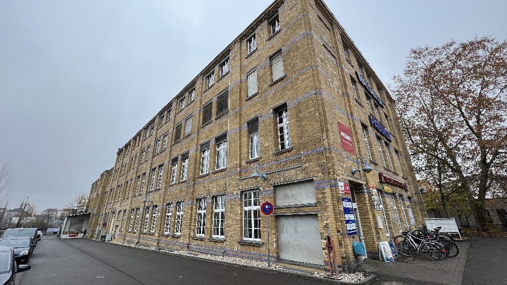 Viergeschossiges Backsteingebäude mit regelmäßigen Fensterreihen, Erdgeschoss teilweise verglast, Waldbaurstraße in Leipzig