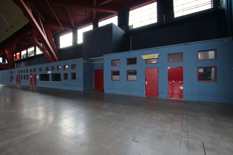 Lange Reihe blauer Boxen mit roten Türen und Fenistern, Betonboden, An den Tierkliniken in Leipzig