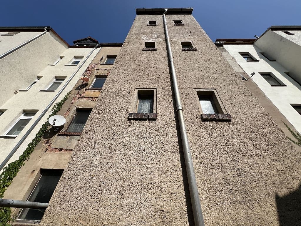 Fünfgeschossiges Wohnhaus mit grauer Putzfassade und regelmäßigen Fensterreihen, Käthe-Kollwitz-Straße in Altenburg