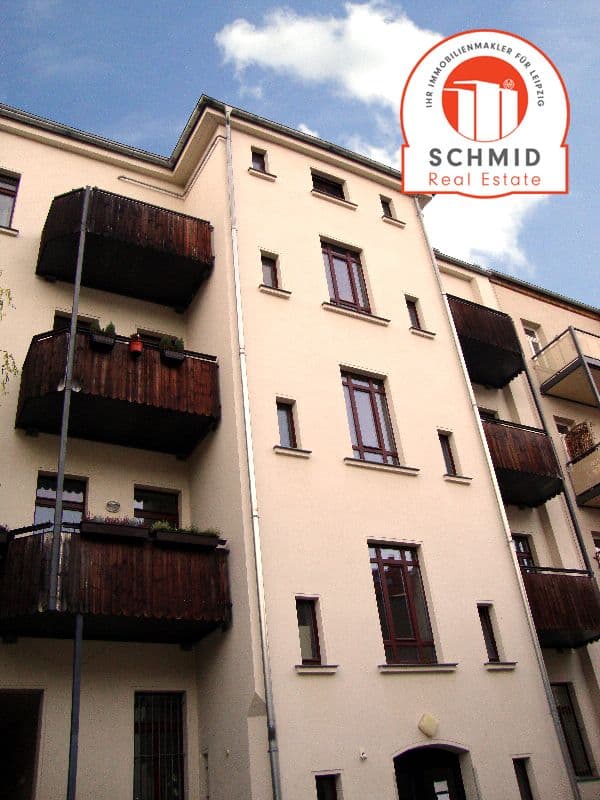 Viergeschossiges Wohnhaus mit beiger Fassade, dunkelbraune Holzbalkone, Breitenfelder Straße in Leipzig