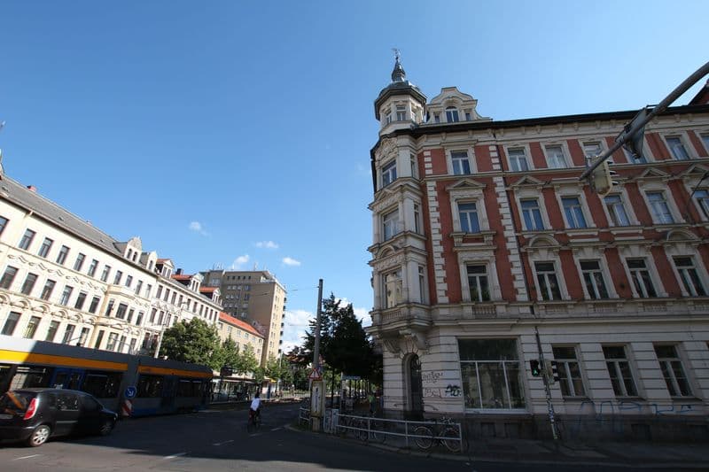 Fünfgeschossiges Gründerzeithaus mit roter Fassade, Ecktürchen und Mansardendach, Karl-Liebknecht-Straße in Leipzig