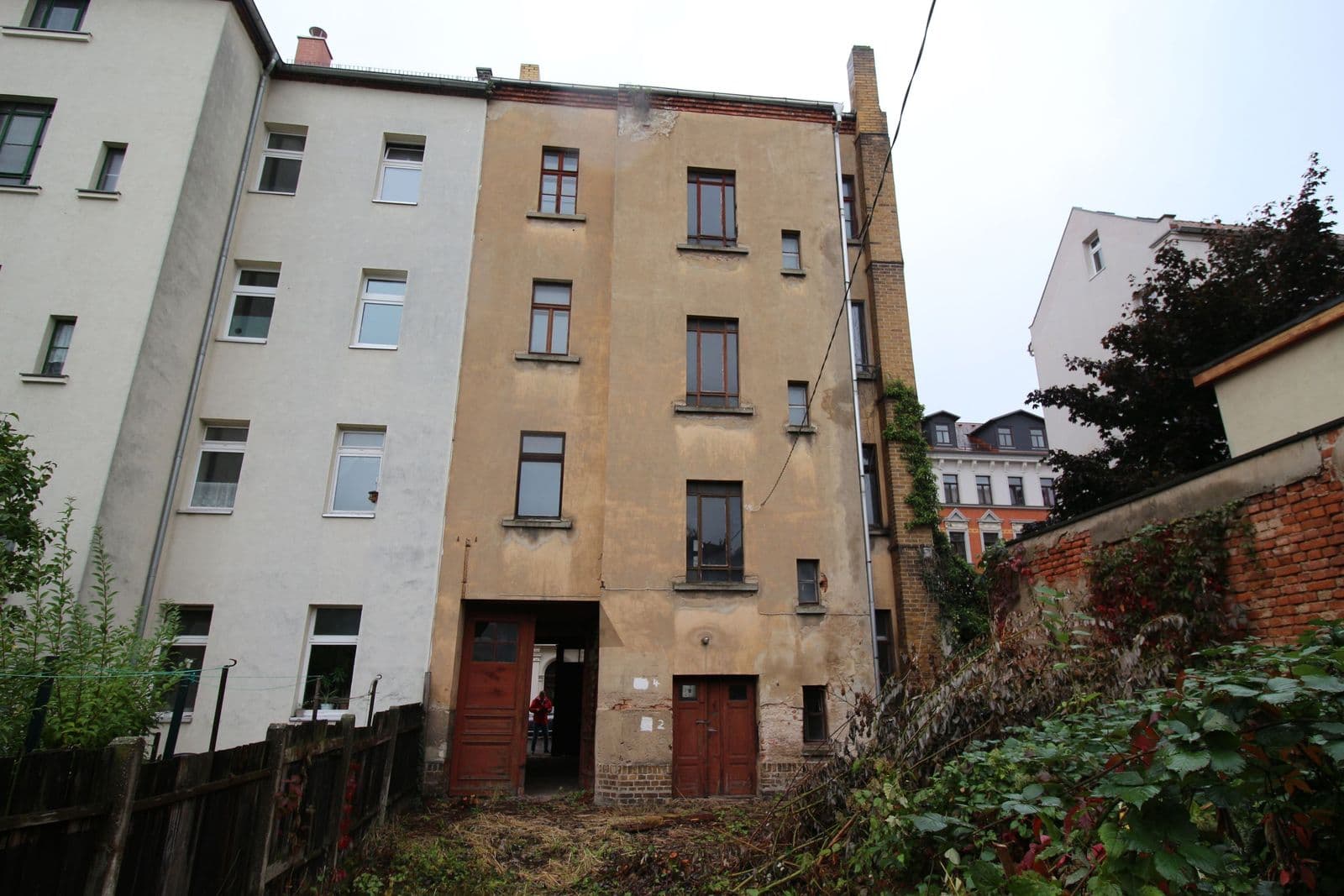 Fünfgeschossiges Wohnhaus mit beige verputzter Fassade, Satteldach, kleine Fenster, Klingenstraße in Leipzig-Kleinzschocher