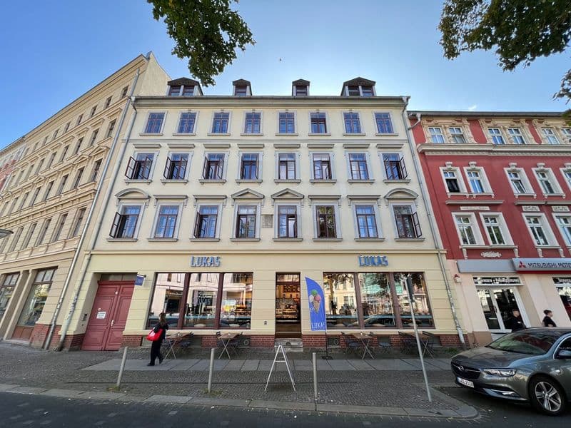 Fünfgeschossiges Gründerzeithaus mit Mansarddach, heller Fassade und regelmäßigen Fensterreihen, Lindenauer Markt in Leipzig