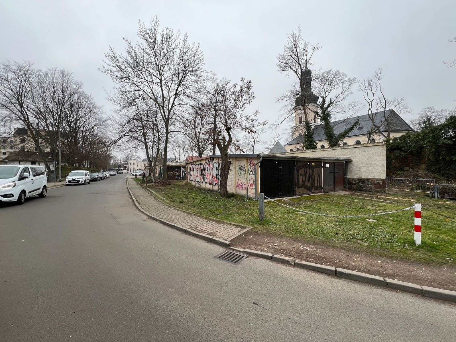 Parkplatz mit Grünfläche, moderner Funktionsbau mit Flachdach und Backsteinmauer, Robert-Blum-Straße in Leipzig