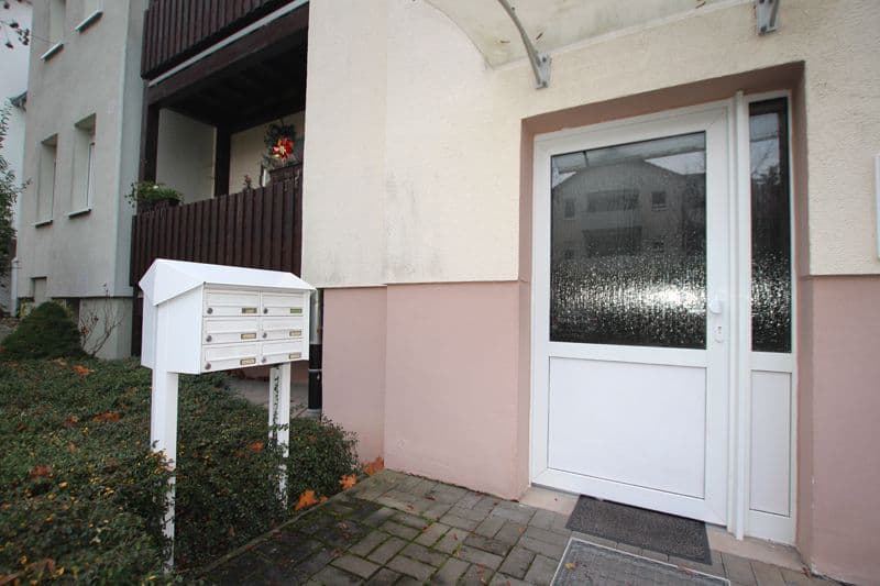 Hauseingang mit weißer Eingangstür, rosa gestrichener Sockel, Briefkasten am Zaun, Wiesenstraße in Delitzsch