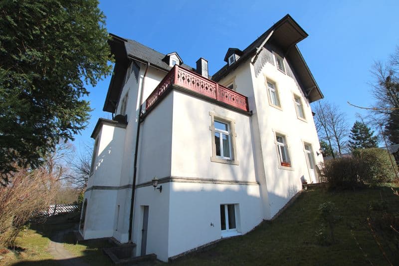 Dreigeschossige Gründerzeitvilla mit weißer Putzfassade, Mansarddach und rotem Holzbalkon, Ulrichstraße in Dresden-Loschwitz