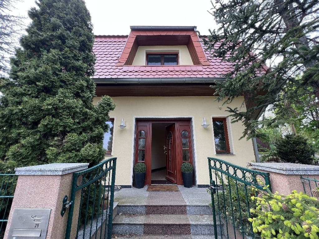 Zweigeschossiges Wohnhaus mit Mansardendach, rote Dachziegel, helle Fassade, rote Eingangstür, Am Wachberg in Leipzig