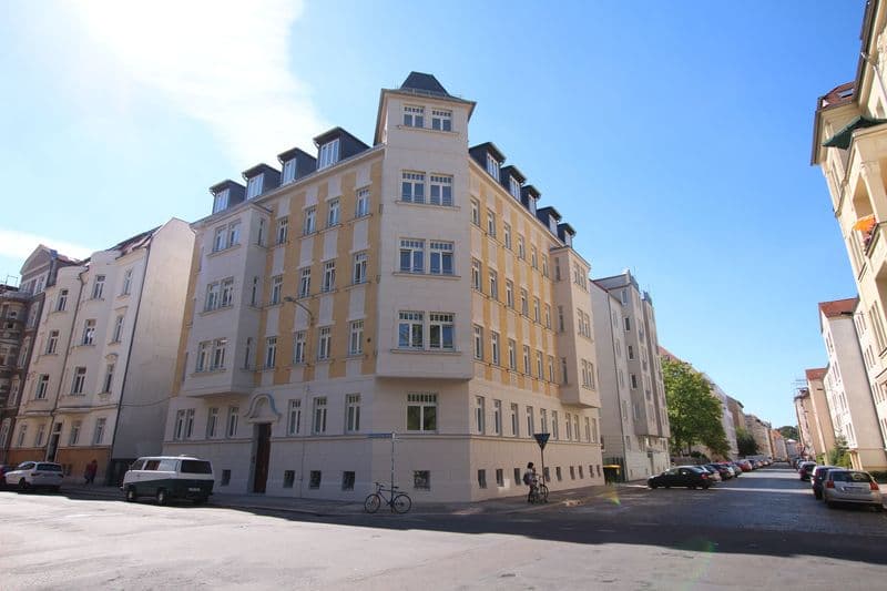 Fünfgeschossiges Wohngebäude mit Mansarddach und Erkern, gelbe Fassade, Bernhard-Göring-Straße in Leipzig