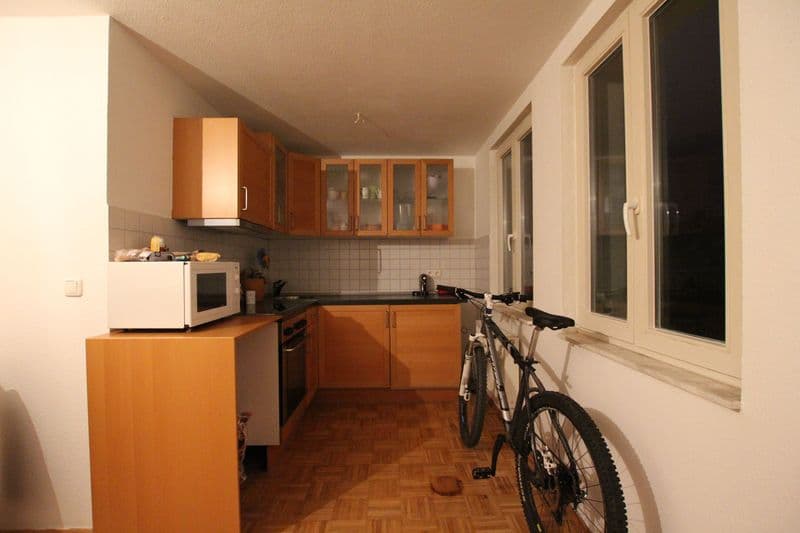 Küche mit Holzschränken, Fliesenspiegel, Herringbone-Parkettboden, großes Fenster