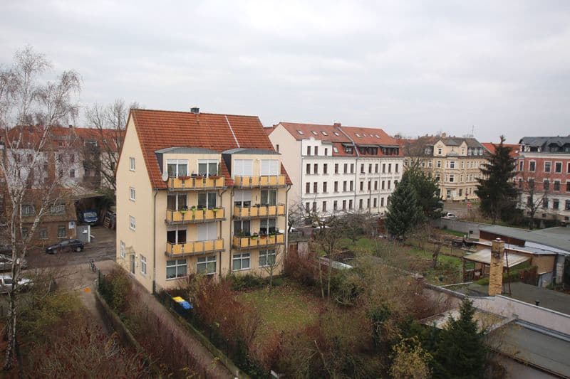 Viergeschossiges Wohnhaus mit Satteldach und roten Ziegeln, gelben Balkonen, Breitschuhstraße in Leipzig-Großzschocher