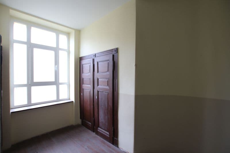 Leeres Zimmer mit Holzfenster, dunkelrote zweiflügelige Holztür, Holzdielen, Wände zweifarbig gestrichen